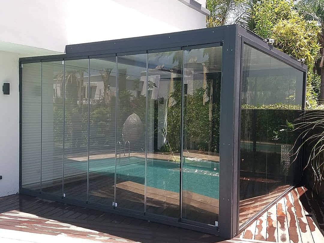 Véranda vitrée au bord de la piscine, réalisée par MZL